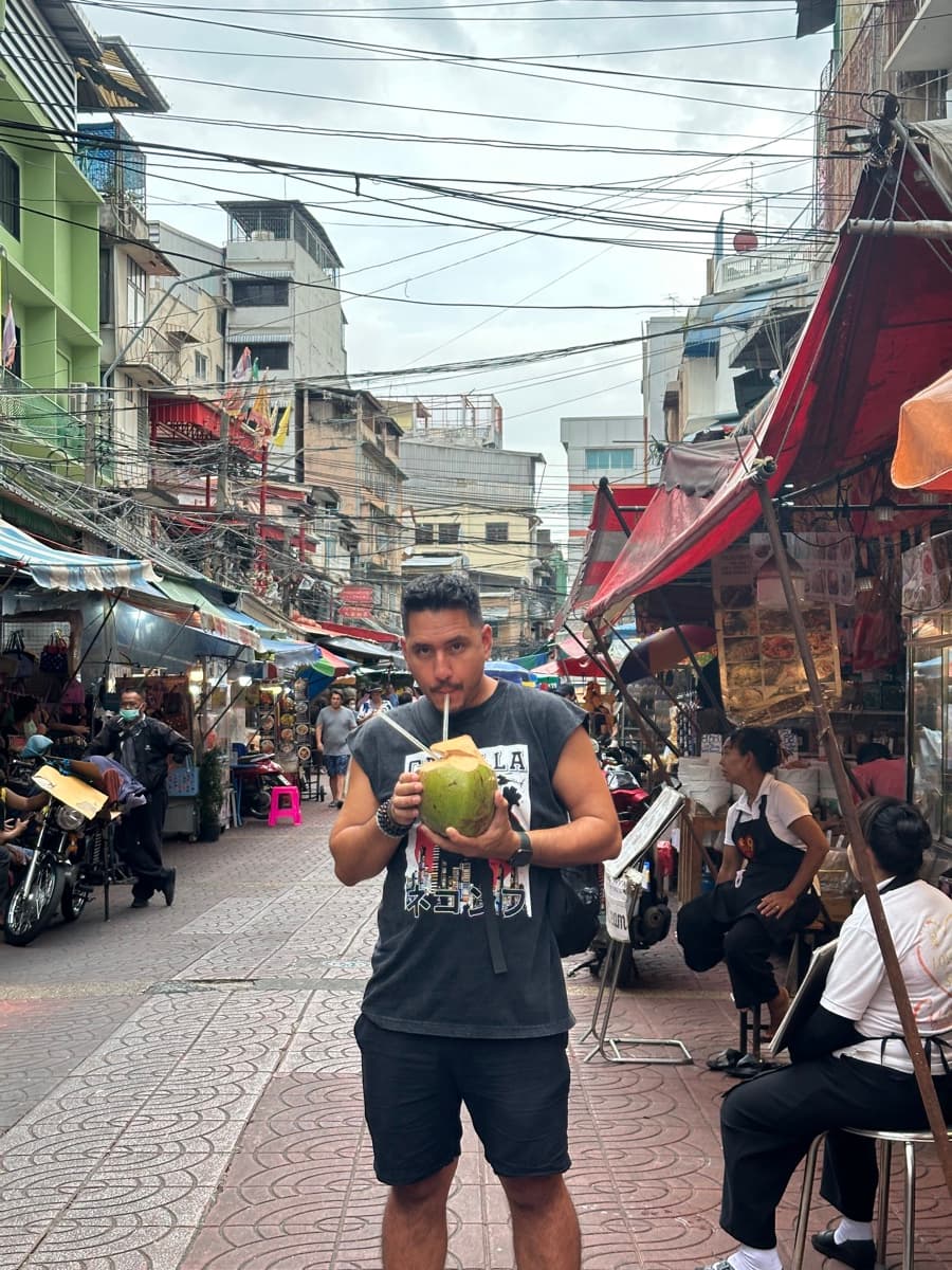 Arni drinking a fresh coconut in Chinatown