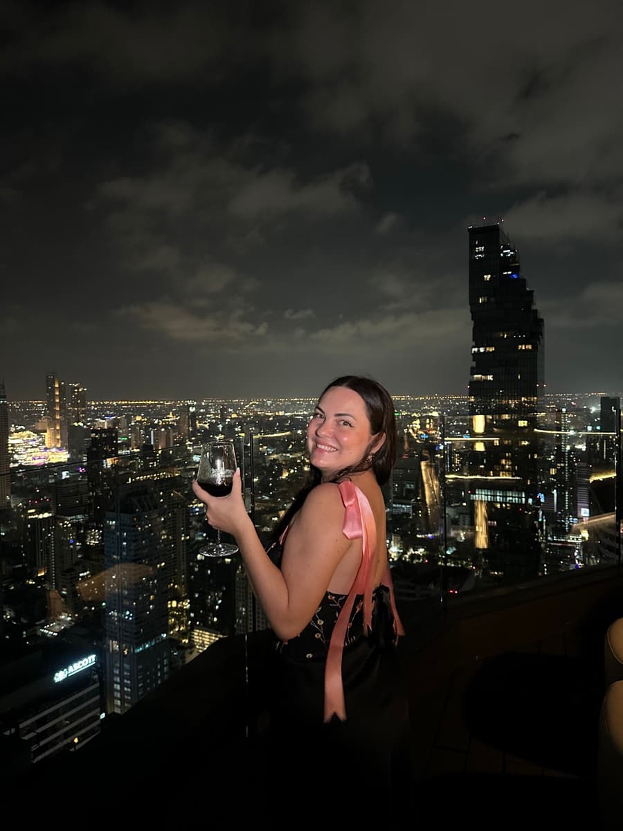 Valeria at a rooftop bar with the Mahanakhon tower at night
