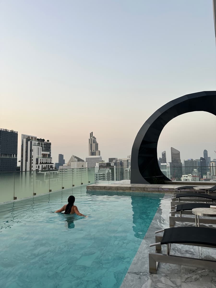 Valeria in a rooftop pool above the Bangkok skyline