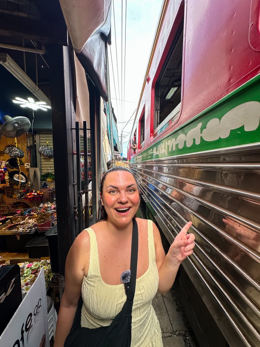 Valeria beside the train at Maeklong Railway Market