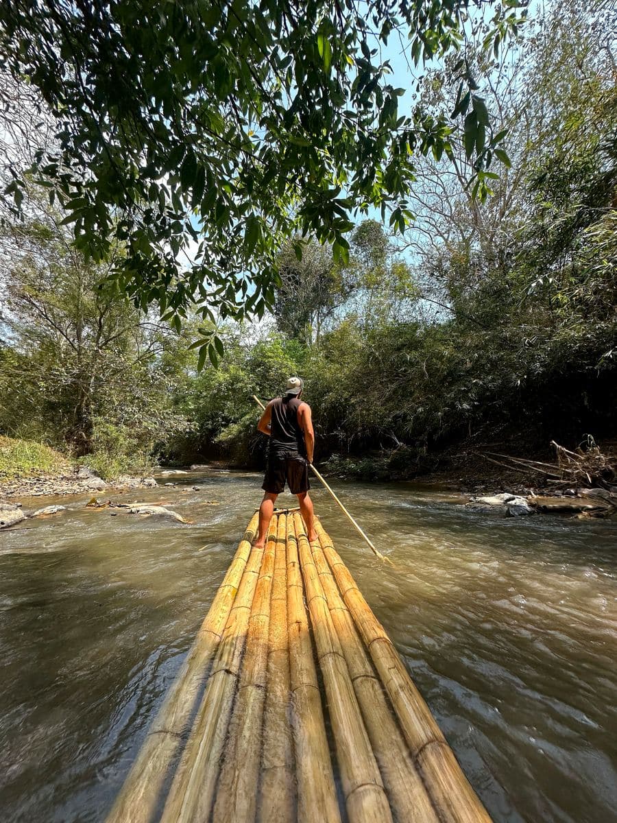Poling a bamboo raft down the river